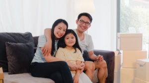 happy asian family sitting on couch